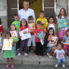 El alcalde, junto a los niños del municipio beneficiados por el reparto de material escolar.