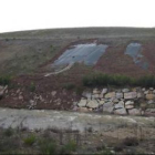 El desprendimiento de tierra del sellado del vertedero de Cistierna es cada vez más evidente.