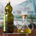 Una botella y una aceitera con aceite de oliva virgen. LUIS TEJIDO