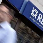 Un hombre camina ante una oficina del banco RBS en Londres.