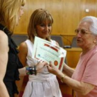 Concepción Rodríguez y Eugenia Gancedo entregan el diploma a una de las alumnas.
