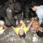 Un policía camboyano aplica un masaje cardiaco a una de las víctimas del accidente.