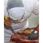 Un operario trabaja en un lineal de despiece de carne. RAMIRO
