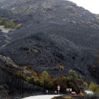 El negro de la ceniza y el olor a hollín envuelven la carretera que une Bárcena con San Pedro, dibujando una imagen dantesca. ANA F. BARREDO