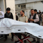 Voluntarios afganos trasladan un cuerpo en una camilla hacia el hospital.
