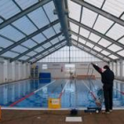 Un empleado del Ayuntamiento realiza labores de mantenimiento en la piscina climatizada