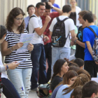 Un grupo de estudiantes esperan a la puerta de su universidad en Sevilla.
