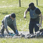 Policías franceses examinan las armas de uno de los zulos de ETA.