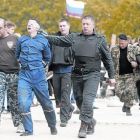Unos prorrusos escoltan a dos hombres con los ojos vendados en Donetsk.