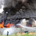 Los bomberos tratan de apagar el fuego declarado en una fábrica de zapatos de Manila.