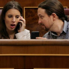 Pablo Iglesias muestra el móvil a Irene Montero durante el pleno en el Congreso.