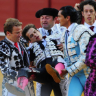 El diestro Julián López "El Juli" es sacado de la Real Maestranza de Sevilla por los matadores José María Manzanares (c) y Antonio Nazaré (d) y su cuadrilla, después de ser cogido por el primer toro de su lote.