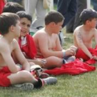 Participantes del torneo de fútbol se toman un respiro entre partido y partido viendo a sus rivales