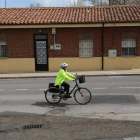 Una mujer sube en bicicleta por la carretera que comunica Armunia con la Valdoncina