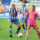 Yuri, autor de dos goles, conduce el balón en el centro del campo ante un  jugador burgalés.