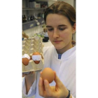 Una investigadora sujeta un huevo contaminado.