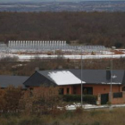 Una vivienda de la urbanización Club de Golf y, al fondo, el huerto solar.