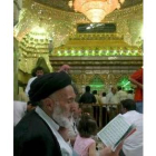 Un clérigo chií iraquí lee el Corán en una ceremonia religiosa