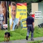 Un hombre pasea junto a varios carteles electorales de los candidatos
