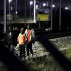Tres inmigrantes se encaminan por las vías del tren con la intención de acceder al Eurotúnel, cerca de Calais.