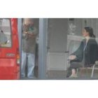 La mujer permanece sentada en una silla en el interior del escaparate del concesionario.