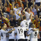 Los jugadores del Valencia celebran con sus aficionados la victoria ante el Mónaco.
