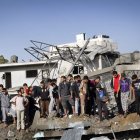 Un grupo de palestinos busca posibles víctimas entre los escombros de un edificio.