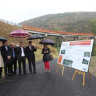 Las autoridades se protegen de la lluvia durante la visita a la variante, al fondo de la foto.