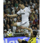 El delantero francés del Real Madrid, Karim Benzema, logra zafarse de un defensor rival.