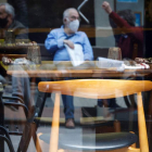 Varios hombres conversan junto a un restaurante vacío en San Sebastián, ayer. JAVIER ETXEZARRETA