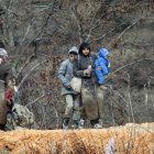 Refugiados sirios, cubiertos de barro, junto a la frontera con Turquía.