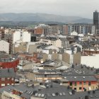 Tejados del barrio de La Puebla, con el perfil de La Rosaleda y el rascacielos al fondo.