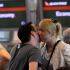 Una pareja se besa junto al mostrador de facturación de Qantas en el aeropuerto de Changi en Singapur, este lunes.