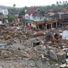 Los residentes caminan entre los escombros en el área devastada por el tsunami. ADI WEDA