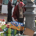 Una persona recoge alimentos tirados en la Plaza Mayor de León. RAMIRO