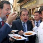 Rajoy  y Herrera degustan un plato de judiones de La Granja en medio del tumulto popular