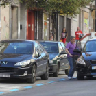 Un controlador del aparcamiento en zona azul (de espaldas), ayer realizando su trabajo en la calle General Vives de Ponferrada.