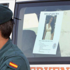 Un guardia civil con la foto que se ha distribuido de Diana Quer.