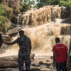 Policías y voluntarios frente a la cascada en la que un árbol mató a 18 personas.