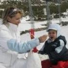 Una madre da la merienda a su hijo en la estación de esquí de Leitariegos