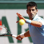 El tenista serbio Novak Djokovic golpea la bola durante la semifinal del Roland Garros que disputó hoy contra el letón Ernests Gulbis, en París.