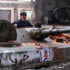 Un activista sirio, al lado de un tanque capturado en el bastión opositor de Homs.