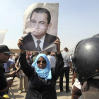 Una mujer sostiene un retrato del expresidente Mubarak, frente a la Academia de la Policía.