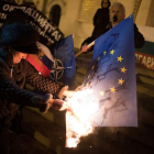 Una manifestante quema una bandera de la Unión Europea durante una protesta en Sofía. VASSIL DONEV