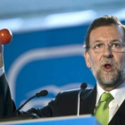 Rajoy exhibe unos tomates en el acto en Málaga.