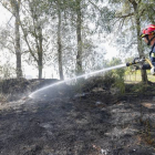 Un bombero refresca la zona después de un incendio. DL (ARCHIVO)