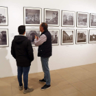 Dos personas contemplan la exposición fotográfica.