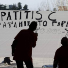 Dos personas pintan un cartel reivindicando el tratamiento para la hepatitis C, el pasado enero en Pamplona.