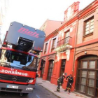 Los bomberos retiran de la acera los cascotes caídos de la cornisa del edificio de Julio del Campo.