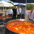 El subdelegado del Gobierno, acompañado del alcalde, junto a las paelleras de pulpo.